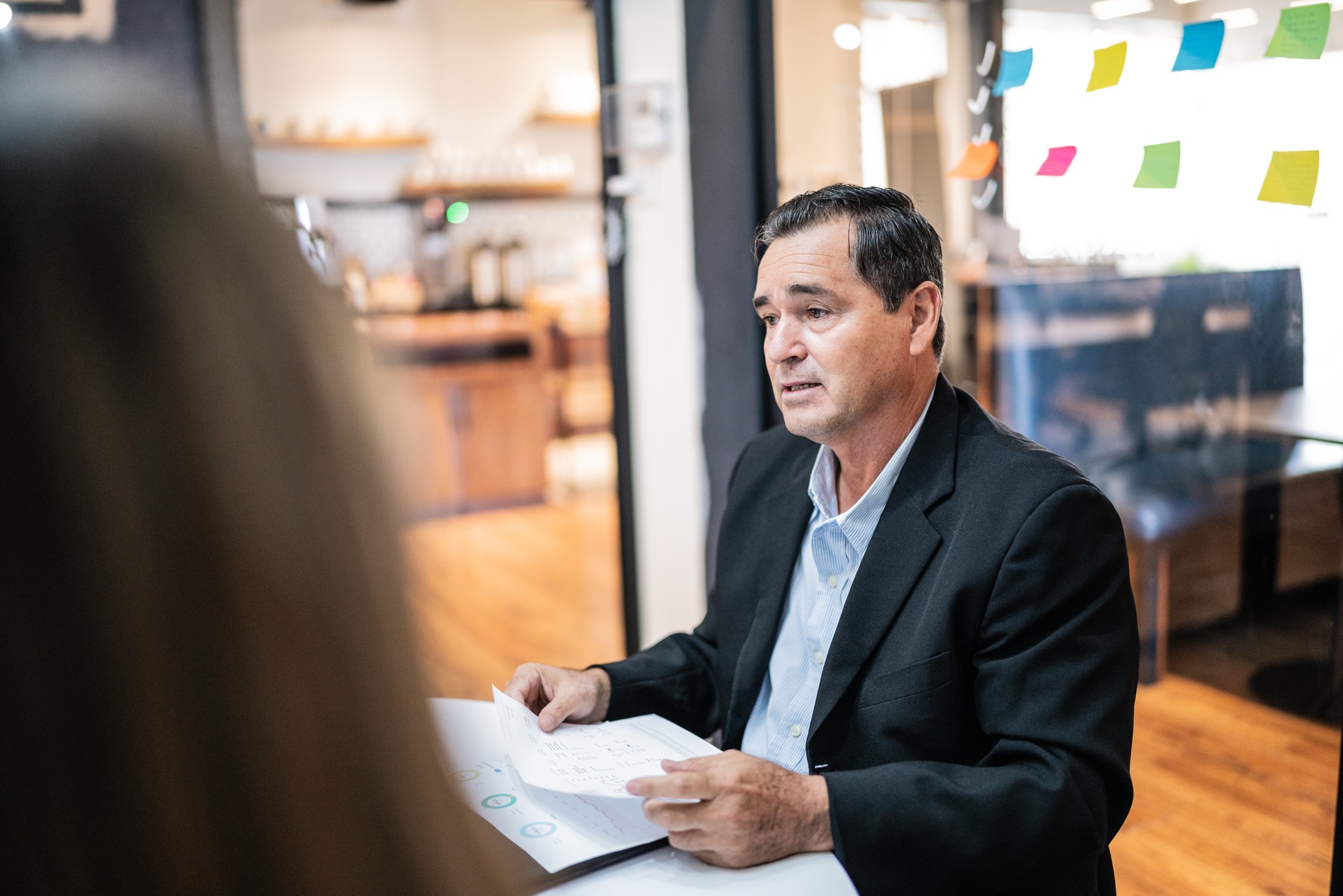 Mature businessman talking to coworkers on a meeting at office